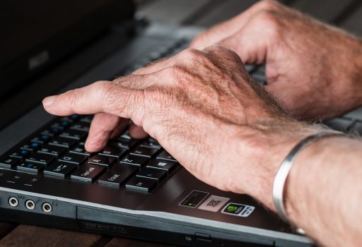 Hände eines älteren Mannes auf einer Tastatur