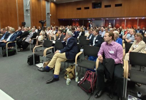 Gäste sitzen bei der Auftaktveranstaltung von digiDEM Bayern im Saal